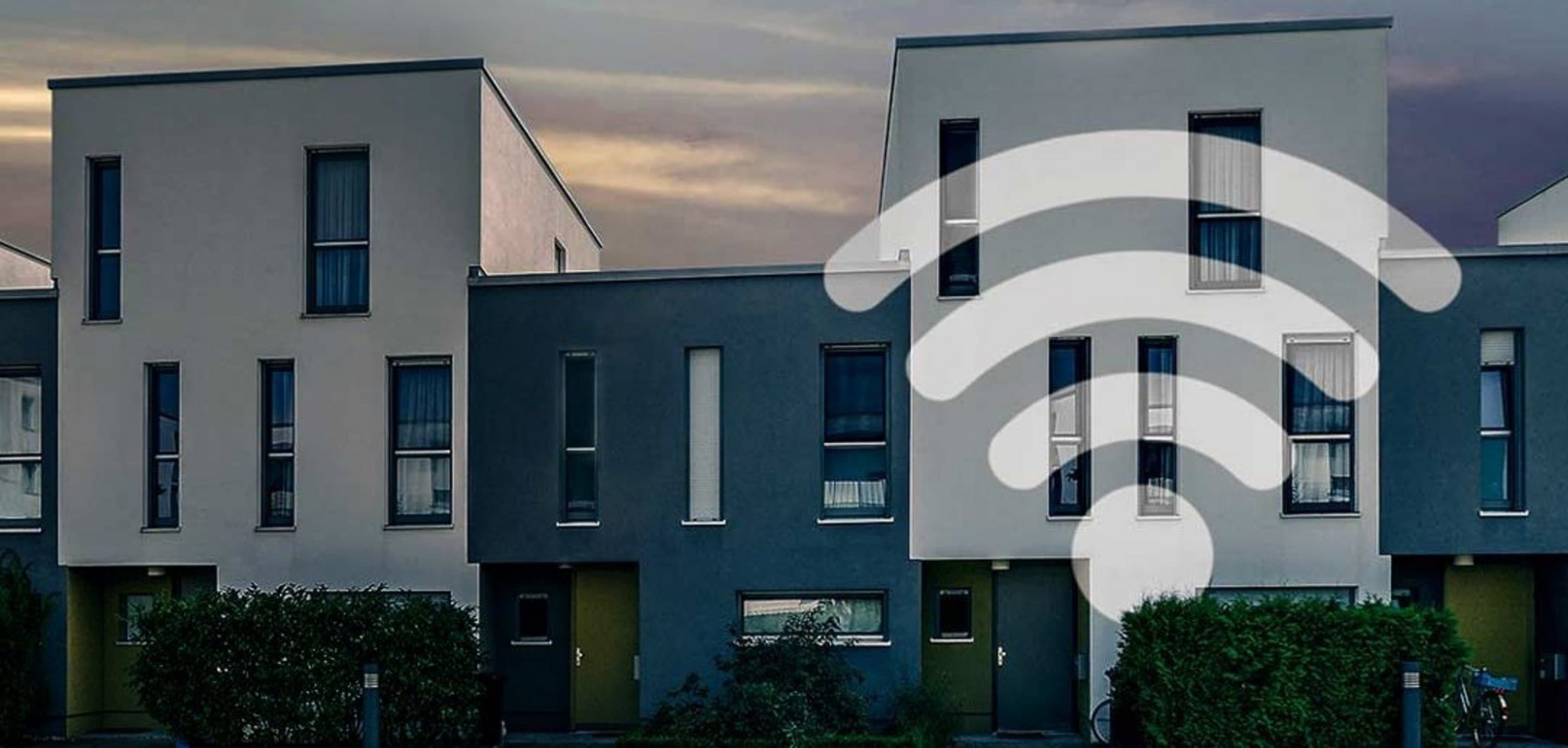 Häuserfront auf der ein WLAN-Symbol abgebildet ist.