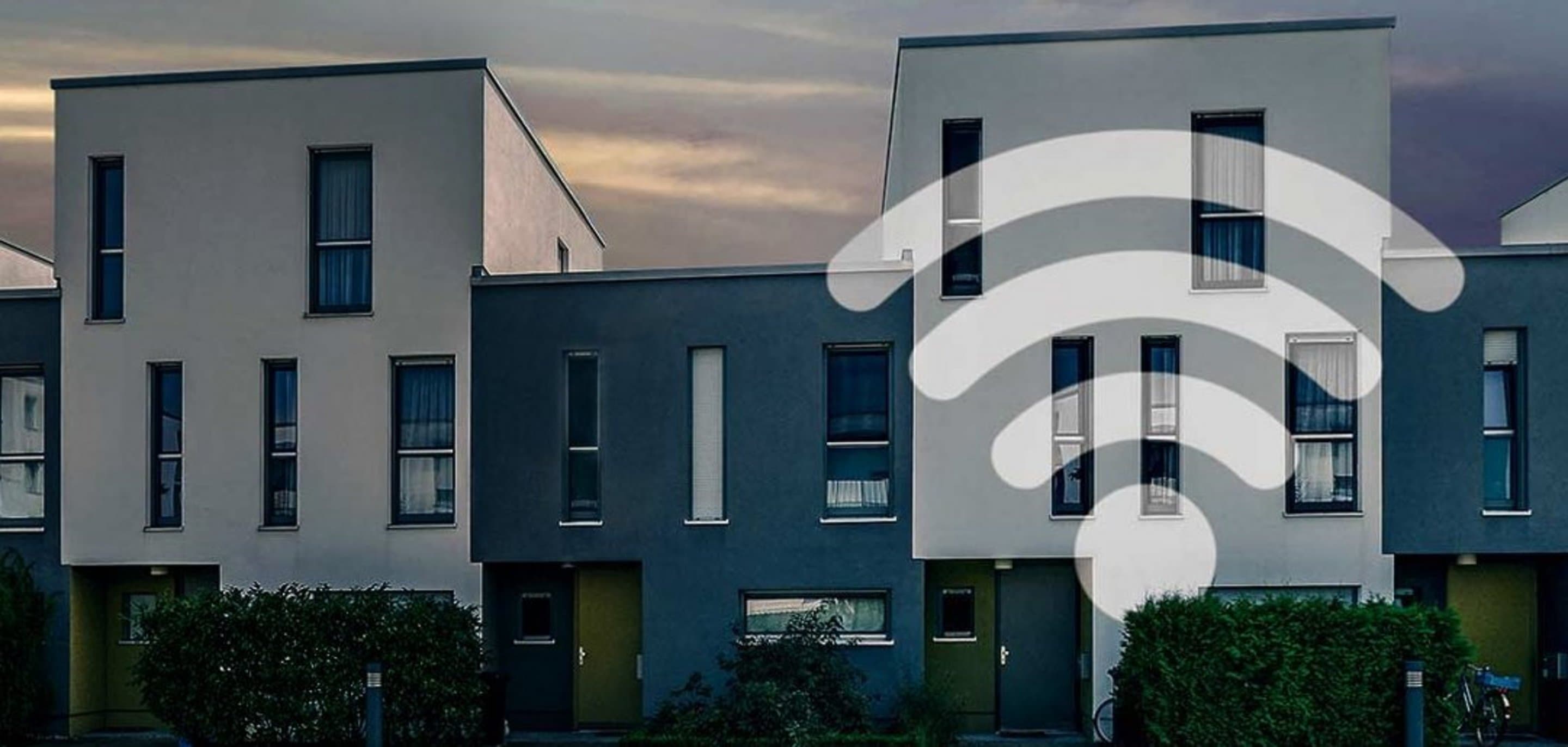 Häuserfront auf der ein WLAN-Symbol abgebildet ist.