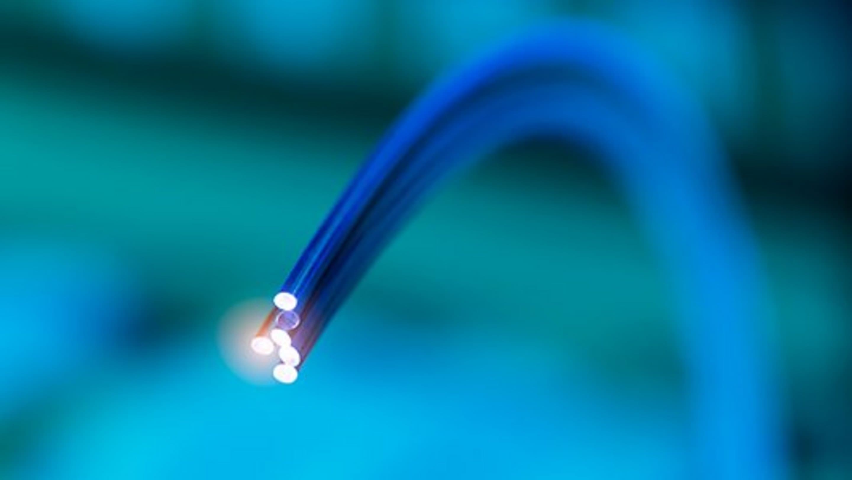 Abbildung blauer Glasfaser-Kabel vor einem hellblauen Hintergrund.