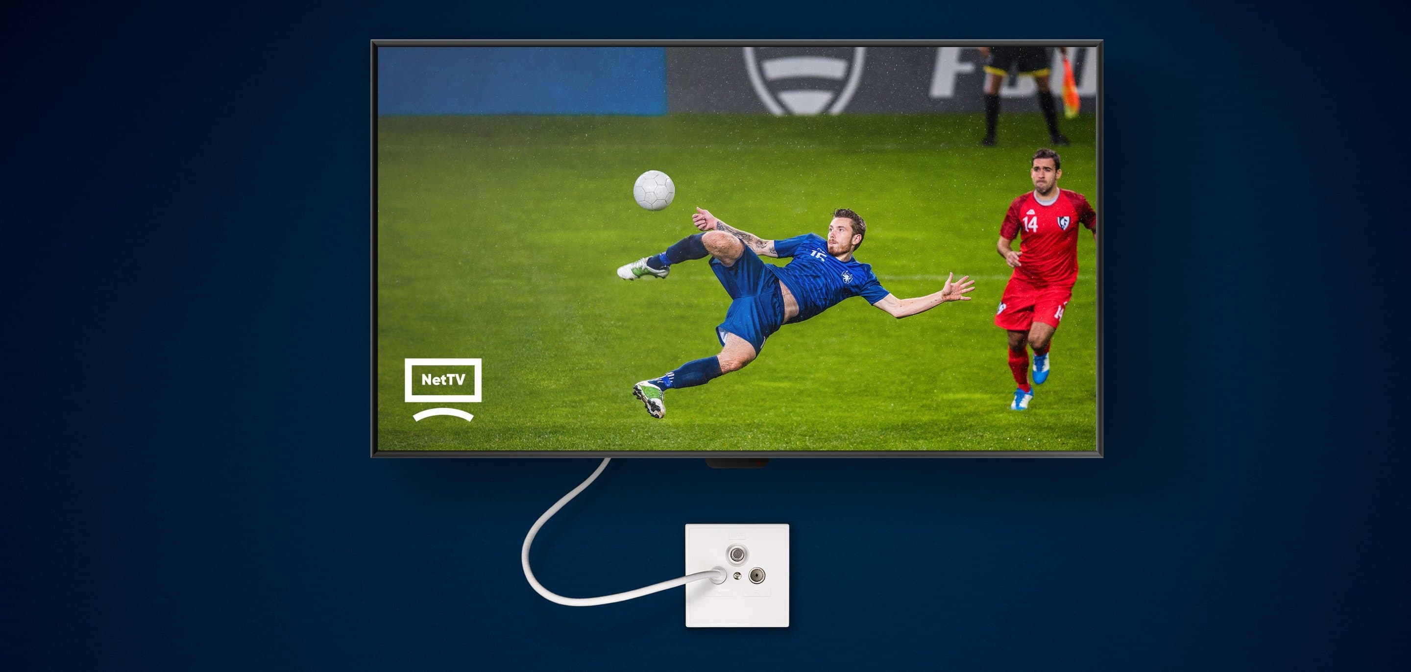 Fernseher an dunkelblauer Wand auf dem ein Fußballer zu sehen ist, der einen Fußball annimmt.