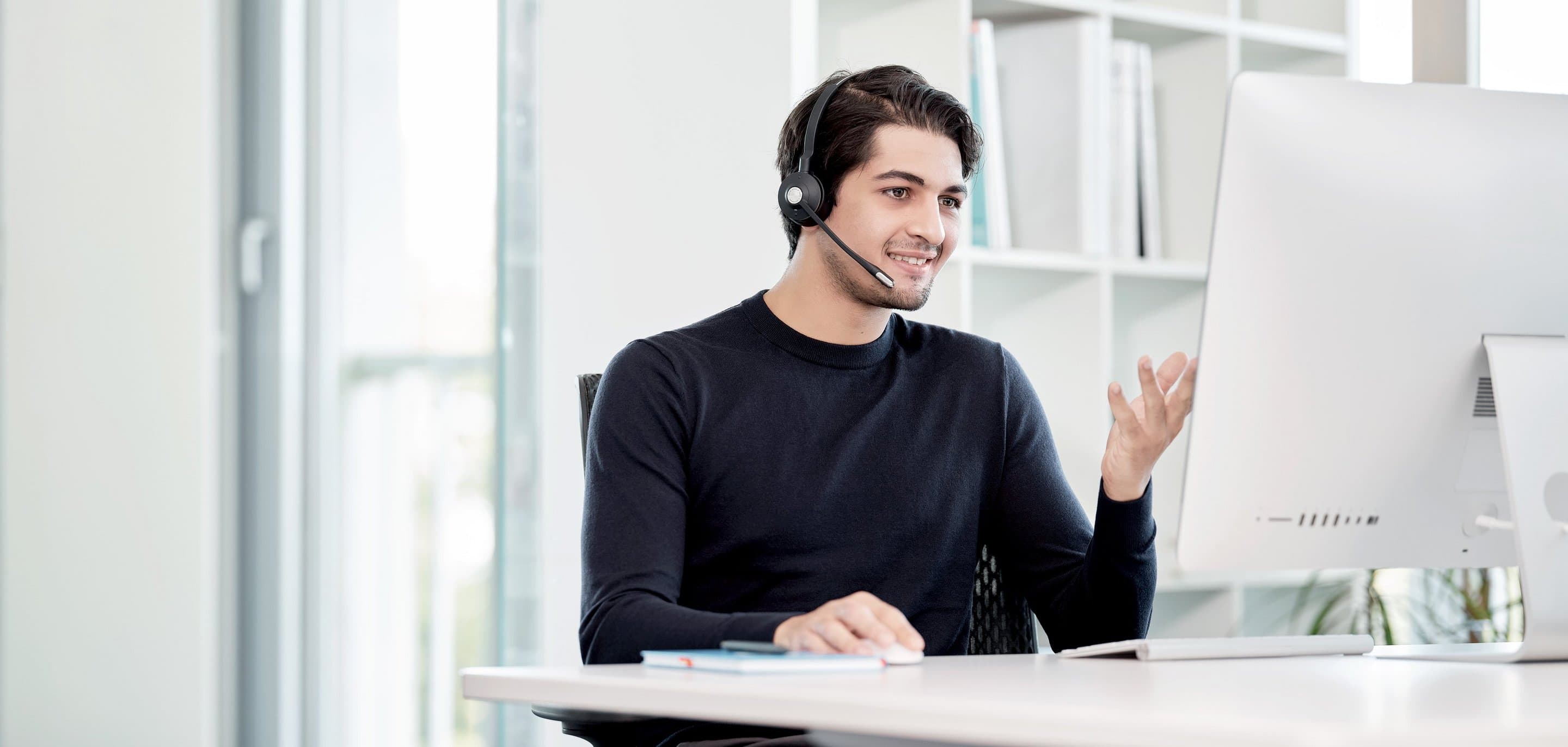Microsoft Teams Telefonie Mann am Schreibtisch telefoniert mithilfe einer Desktopapp.