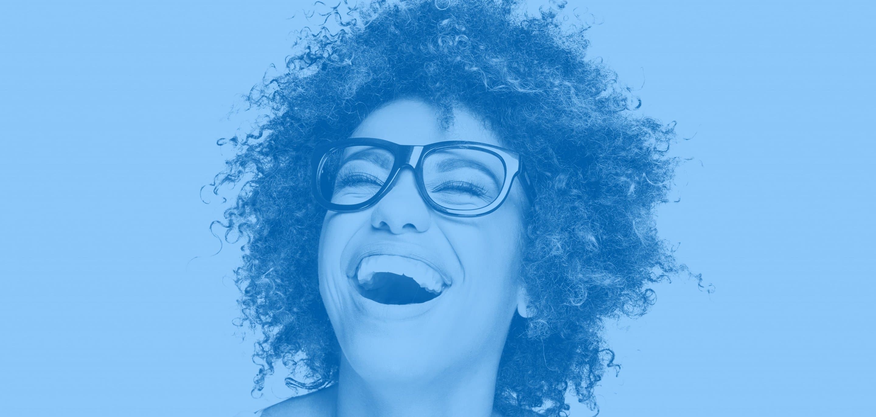Nahaufnahme einer lachenden Frau mit dunkler Brille