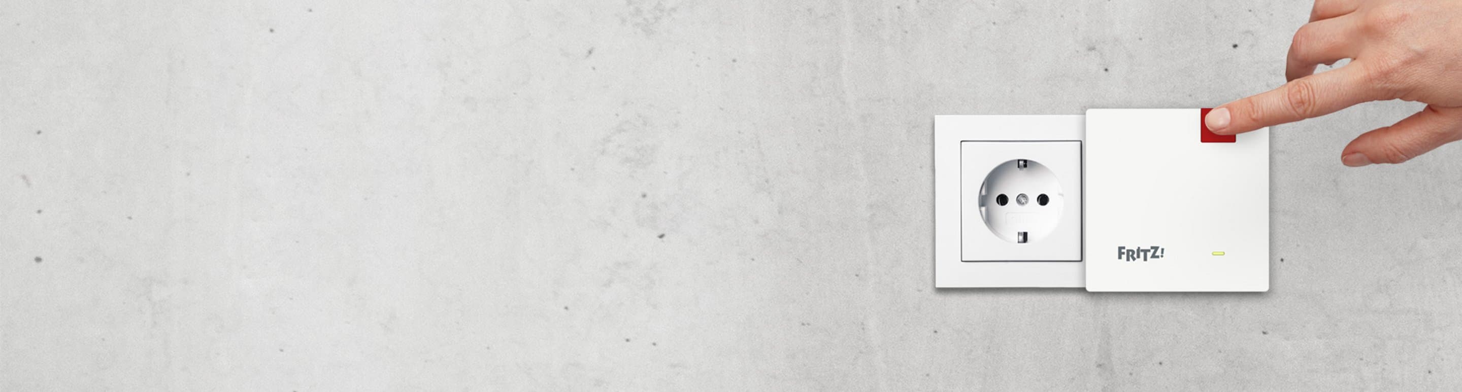 Graue Wand mit einer Steckdose und daneben der Repeater1200AX